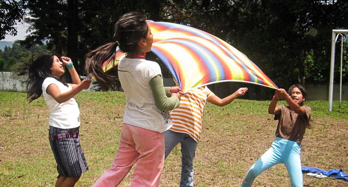 Kids playing with parachute outside