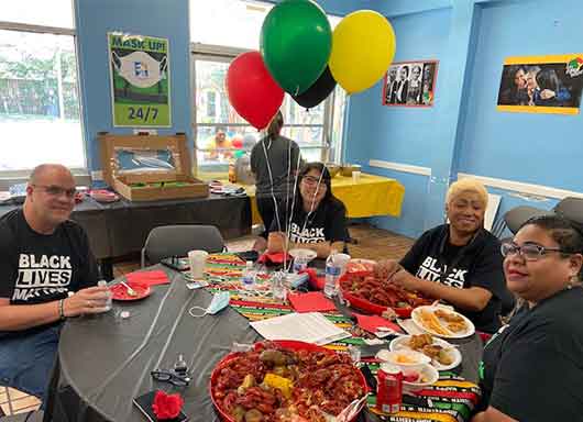 Covenant House Texas Staff sitting together with food and party decorations