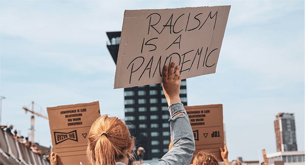 Young woman holding an anti-racism sign at a rally