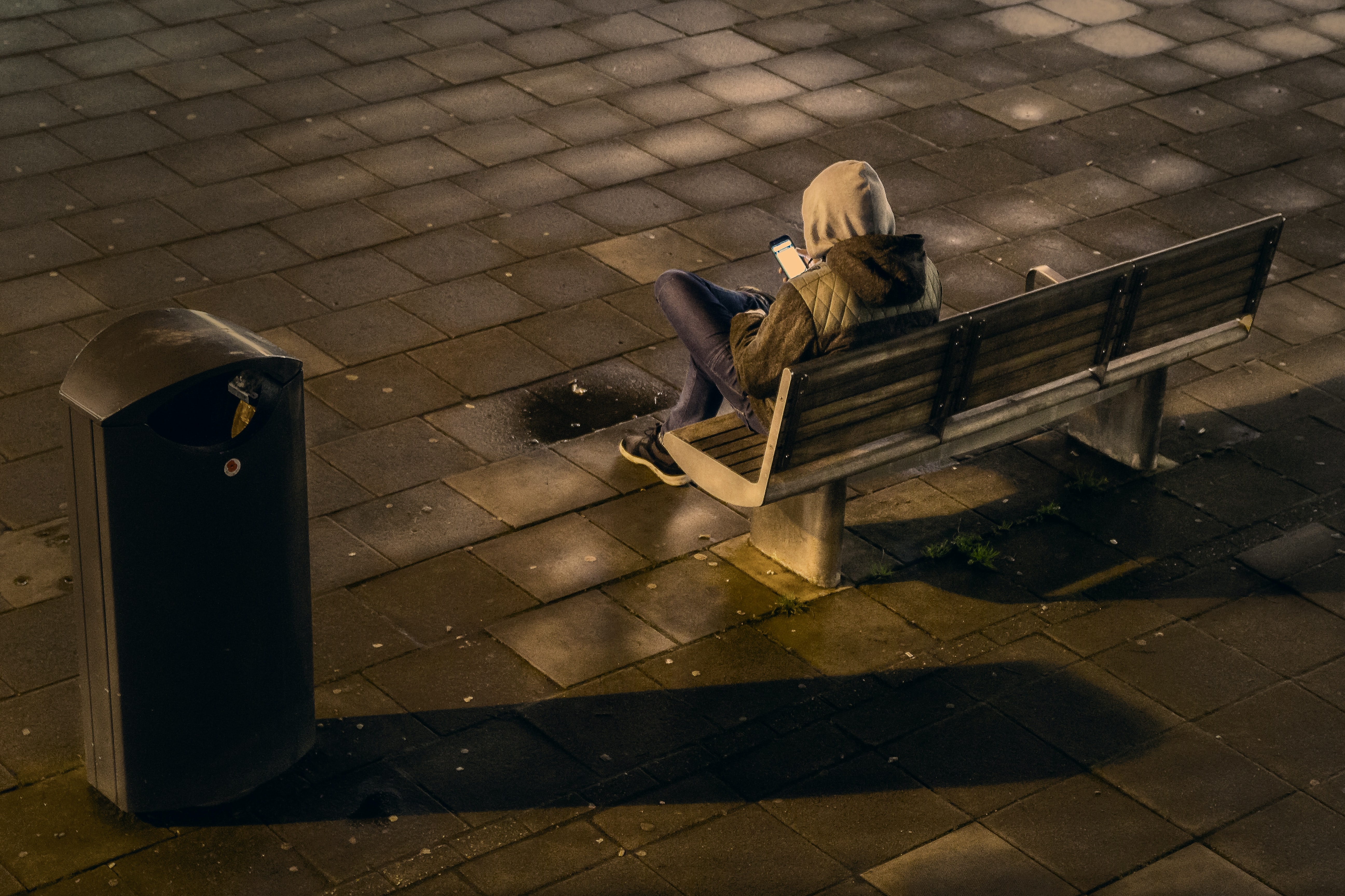 Teen texting on park bench