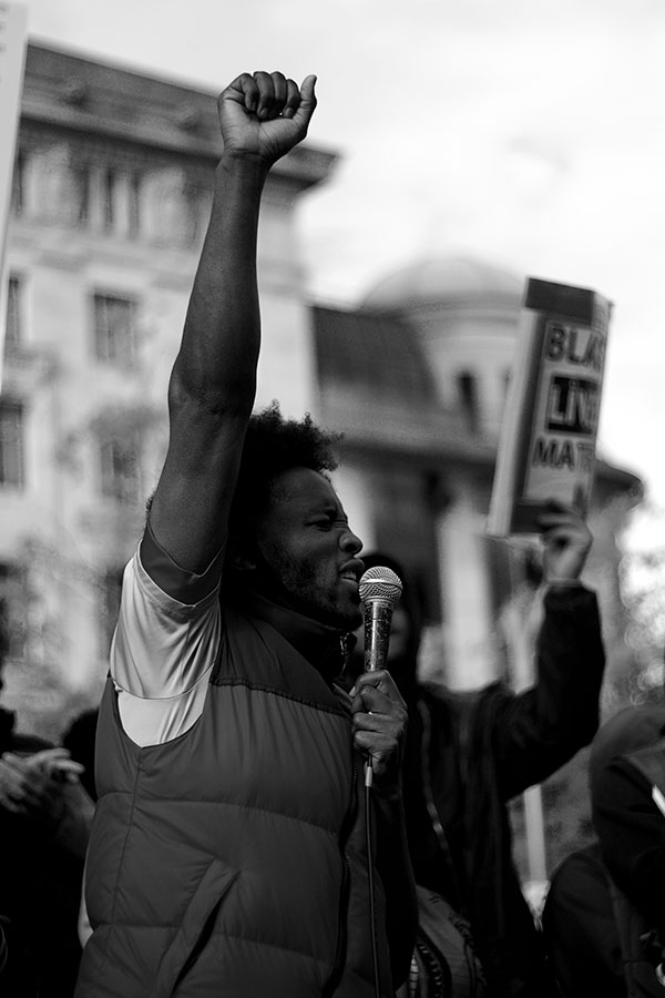 Black man with hand raised at rally