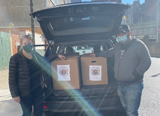 sibley and man posing in front of car trunk full of meals in boxes