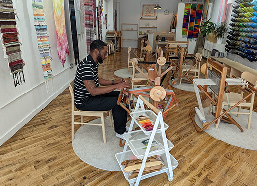 Covenant House staff member Jamel trying weaving at Made in Brooklyn Tour