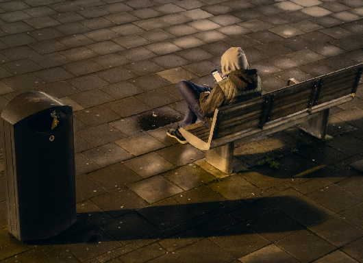 teen texting on bench