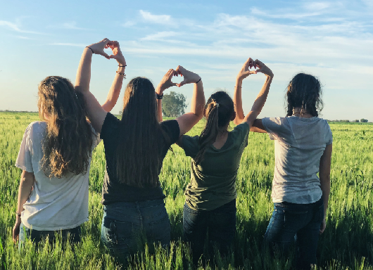 young girls making hearts with hands